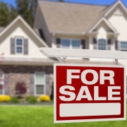 Home For Sale Real Estate Sign and Beautiful New House.