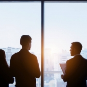 Couple and real estate agent stands near window and speaks before signing contract. Business concept